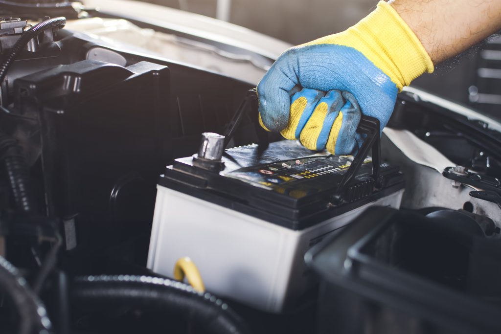 Técnico retirando una batería de automóvil para reemplazarla